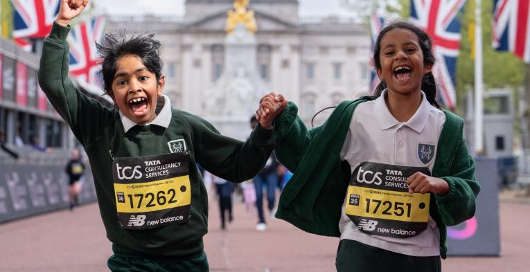 2 children running over the finish line celebrating