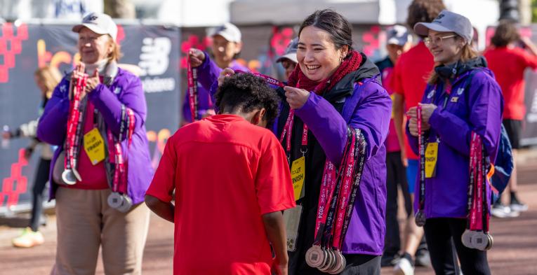 mini marathon volunteers handing out medal