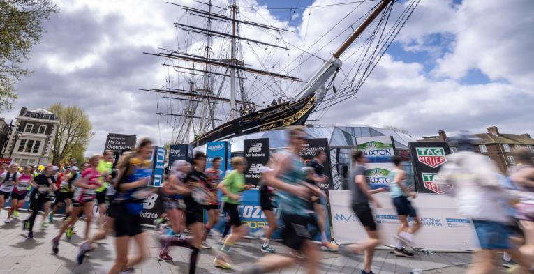 People running with motion blur in front of a ship