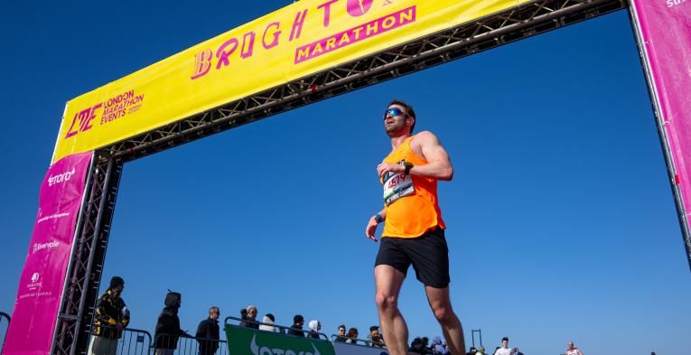 Man runs over the finish line of the Brighton marathon