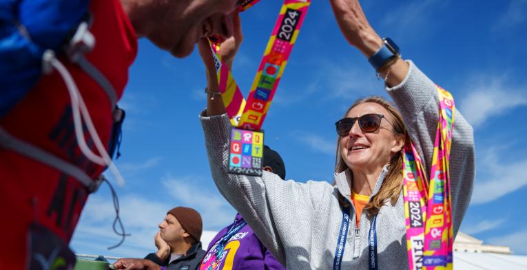 Woman hands medal to participant at the Brighton marathon