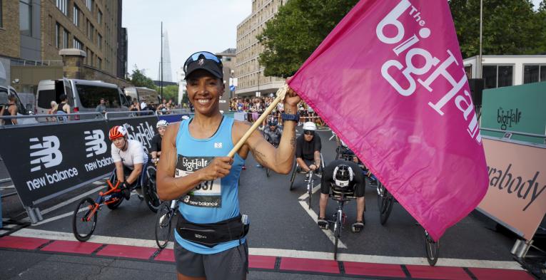 Woman holding a flag at the finish line of the big half