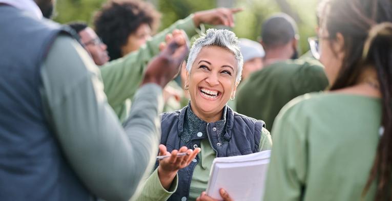 Person holding clipboard and pen smiling