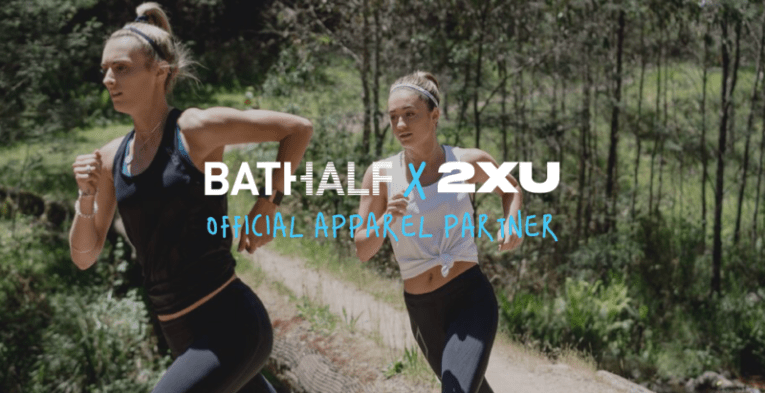 Two woman running through a trail and some super imposed text advertising "2XU" apparel