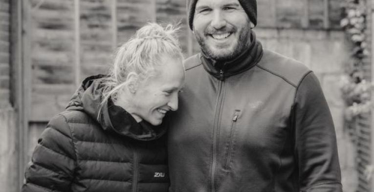 A lady smiling and leaning against a man who is also smiling.