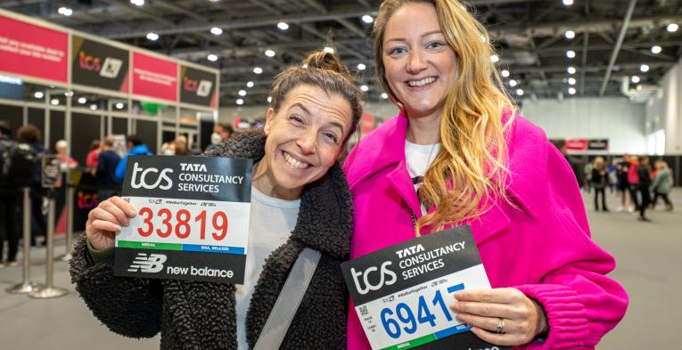 Runners pose for a photo with their bib numbers at the TCS London Marathon Running Show 