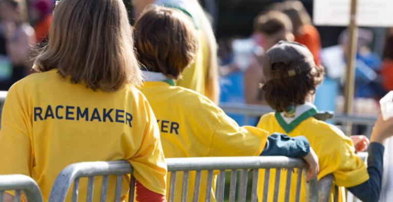 Course marshals leaning against a fence.