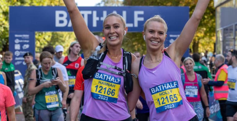 Two happy runners with their hands raised.