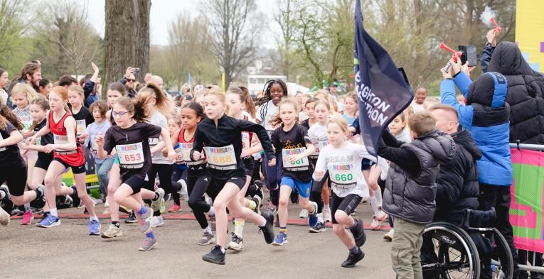 Children running at the start line of the Brighton mile race.