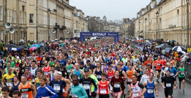 Loads of people running through Bath in quite colourful sportswear