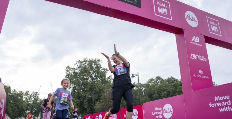 An adults congratulates a child as they cross the Finish Line