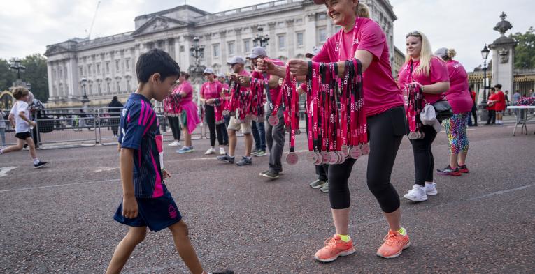 Volunteers hand out medal at the Westminster Mile Finish Line