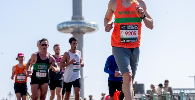 Runners go past the Brighton i360