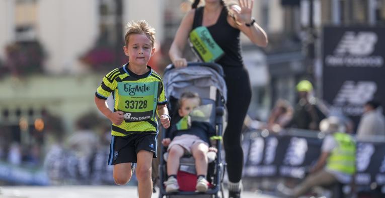 Mum running with boy and pushchair