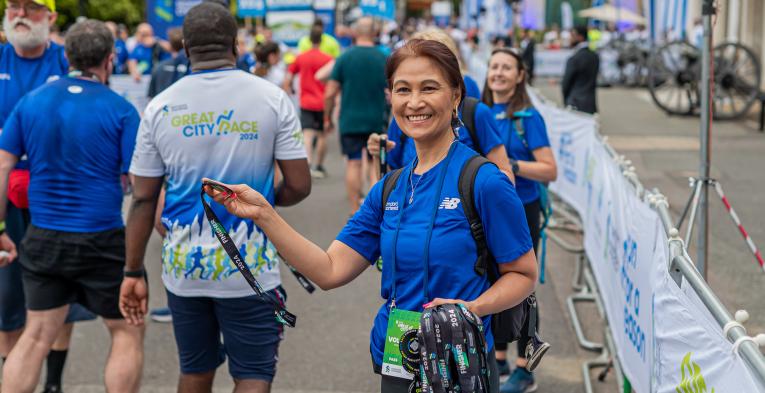 Great City Race volunteer handing out medals