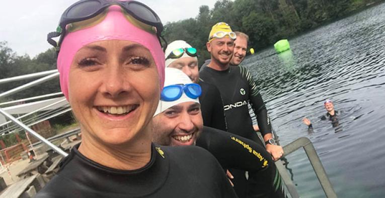 Swimmers wearing swimming caps and smiling