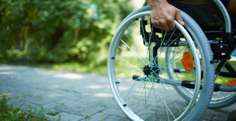 Wheelchair user pushing themself through a park