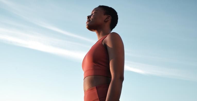 A woman training outside under blue skies