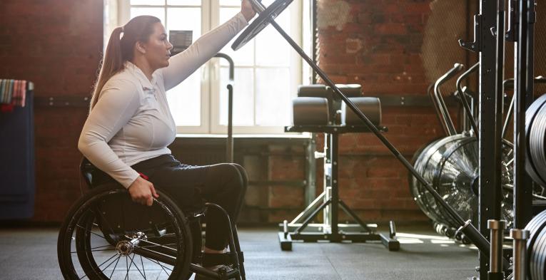 Wheelchair user in the weights area of the gym