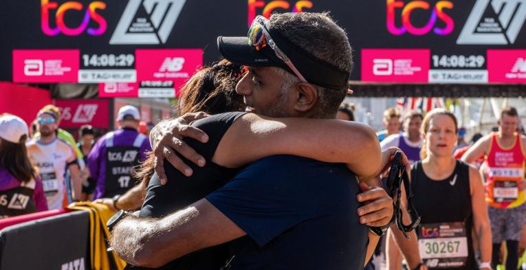 Runners hug at the finish of 2022 TCS London Marathon