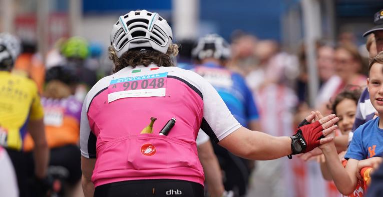 Riders giving high fives to spectators as they pass through during The RideLondon Sportives.