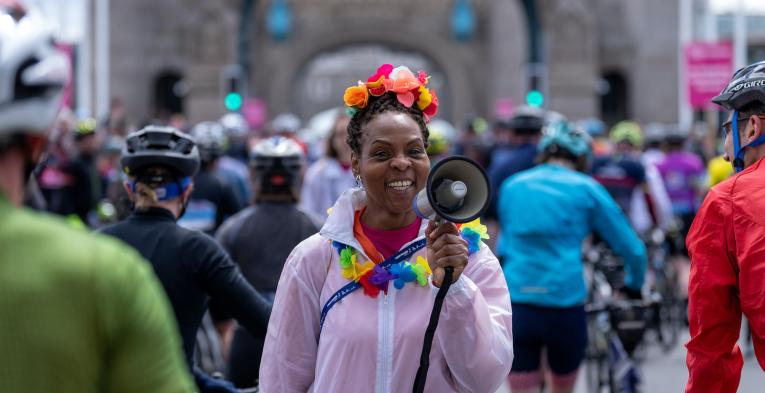 A smiling volunteer with a megaphone on Tower Bridge during RideLondon