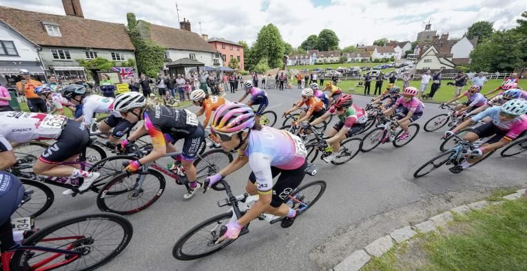 A group of elite cyclists passes through a village