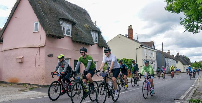 Riders cycle through a village in Essex