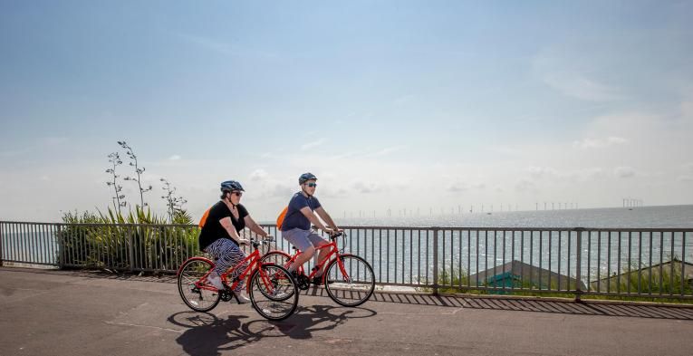 Two riders cycling along the coast