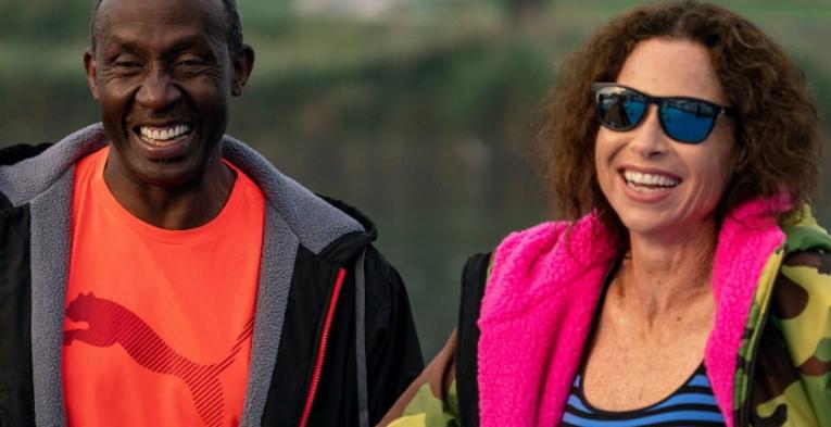 Linford Christie, Jamaican-born British sprinting legend and 1992 Olympic 100m gold medallist, smiles with Hollywood star Minnie Driver, before taking part in the half-mile swim