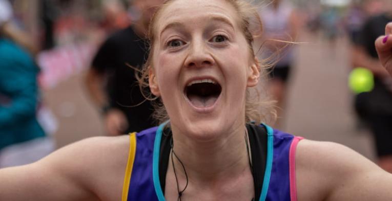 A runner celebrates after finishing the Virgin Money London Marathon