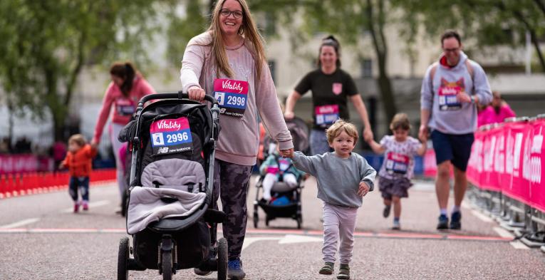 Children, adults and buggies make their way down The Mall in central London