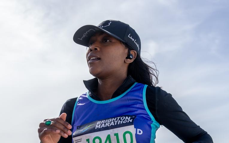 Woman running Brighton marathon in a hat