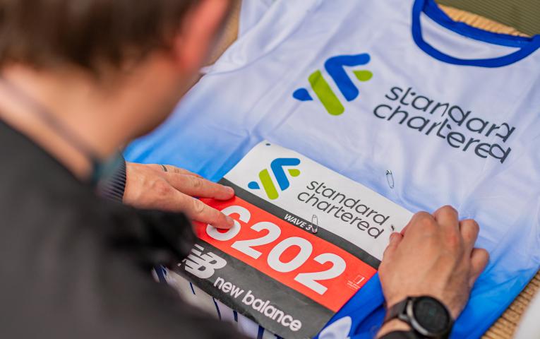 A runner attaches their Great City Race bib to their vest