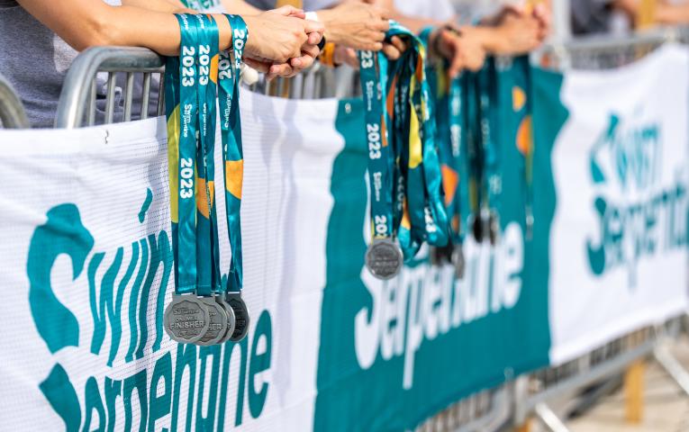 Medals being handed out by volunteers at 2023 Swim Serpentine