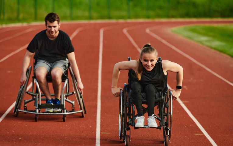 Two wheelchair users enjoying their outdoor track session