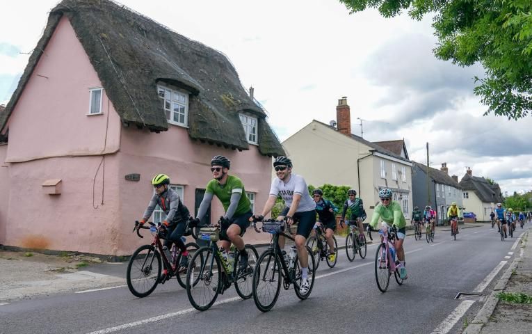 Riders cycle through a village in Essex