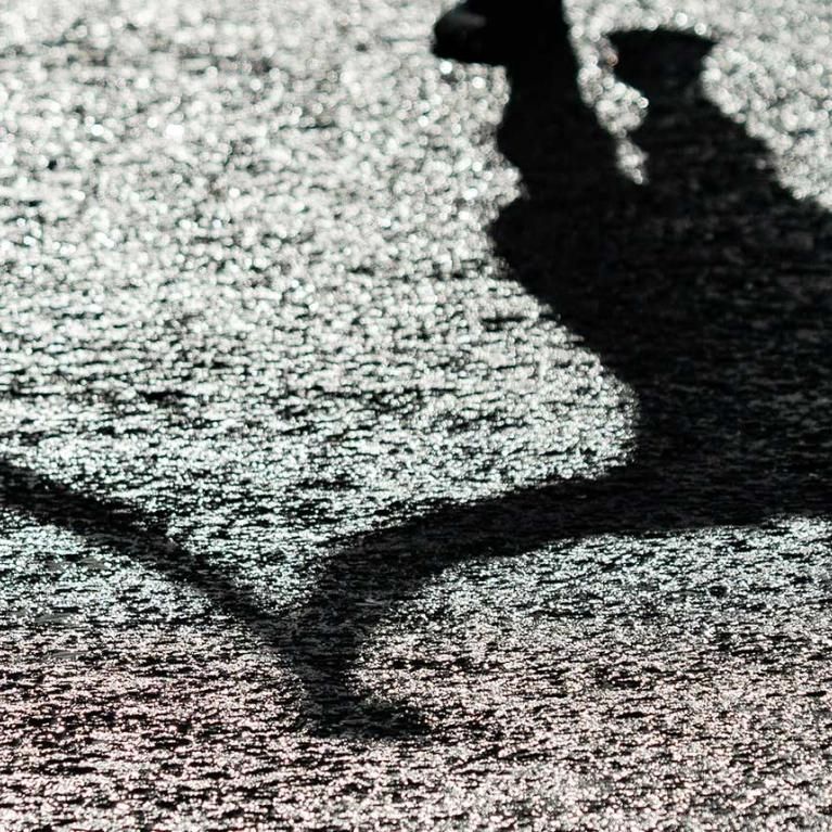 A Shadow of mass runners celebrating as they cross the finish line after completing The 2021 Virgin Money London Marathon