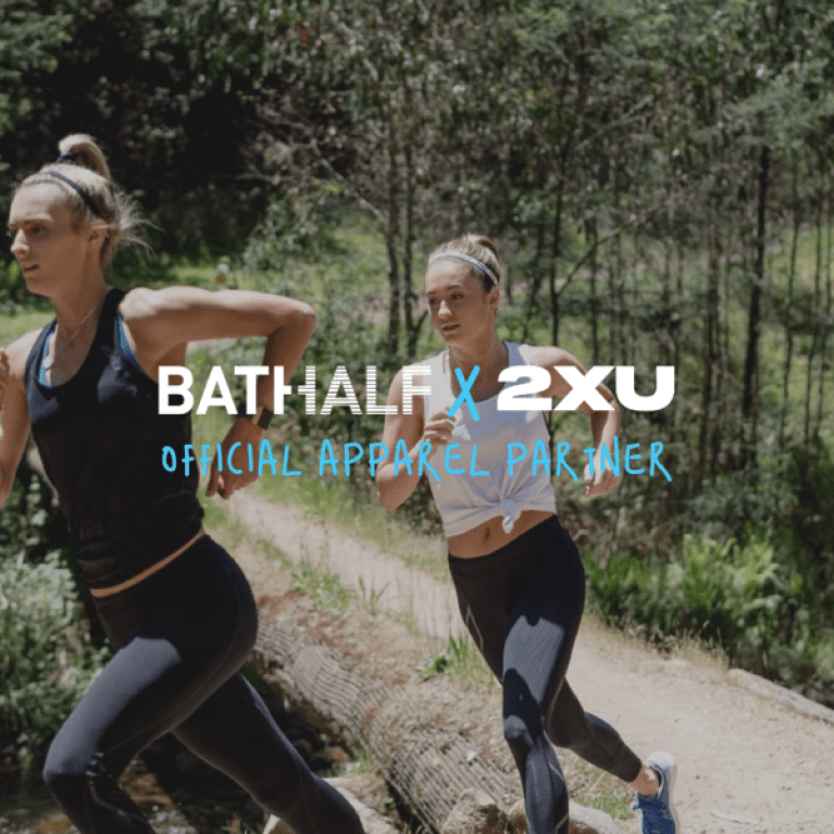 Two woman running through a trail and some super imposed text advertising "2XU" apparel