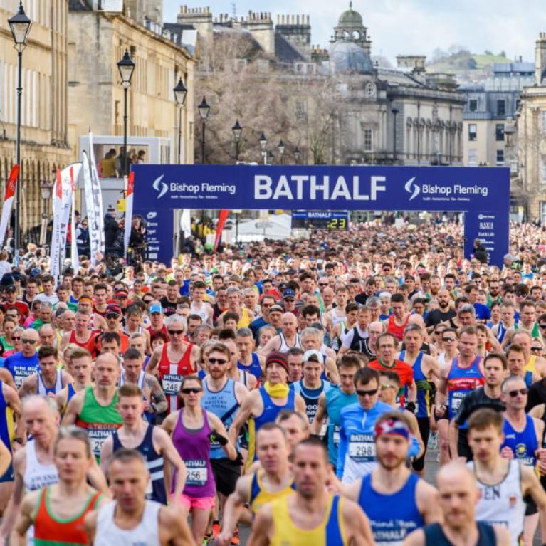 Loads of people in colourful sportswear running through Bath.