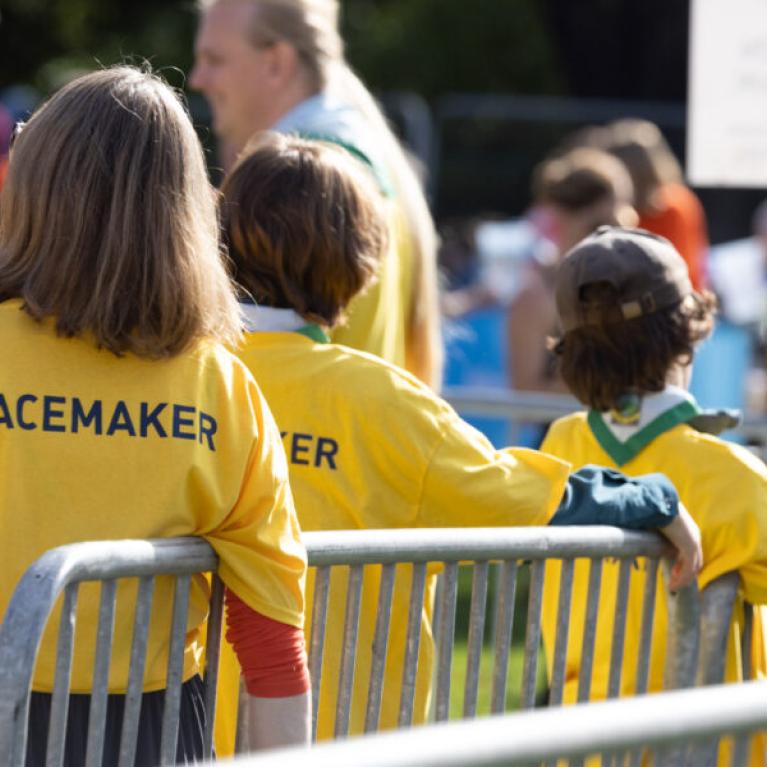 Course marshals leaning against a fence.