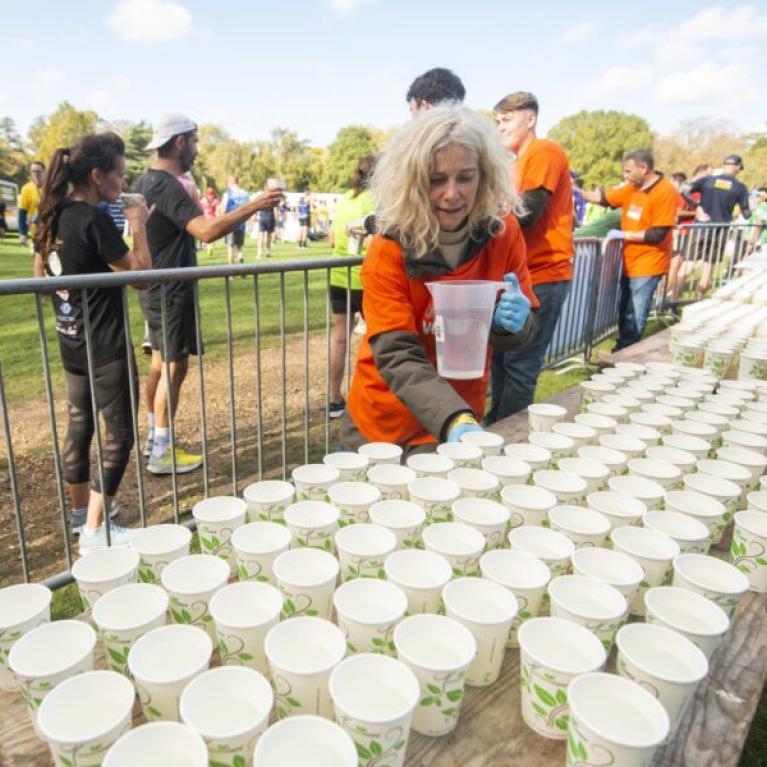 Course marshal filling cups with water.