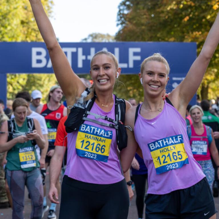 Two happy runners with their hands raised.