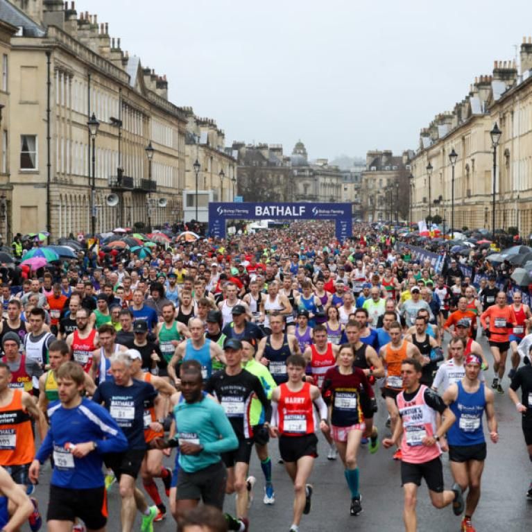 Loads of people running through Bath in quite colourful sportswear