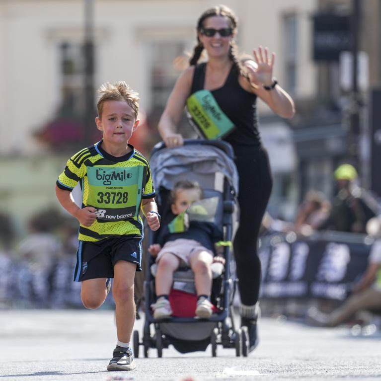 Mum running with boy and pushchair