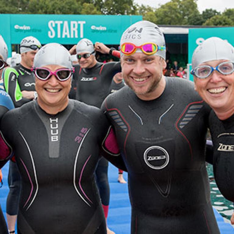 Four swimmers looking at the camera smiling.