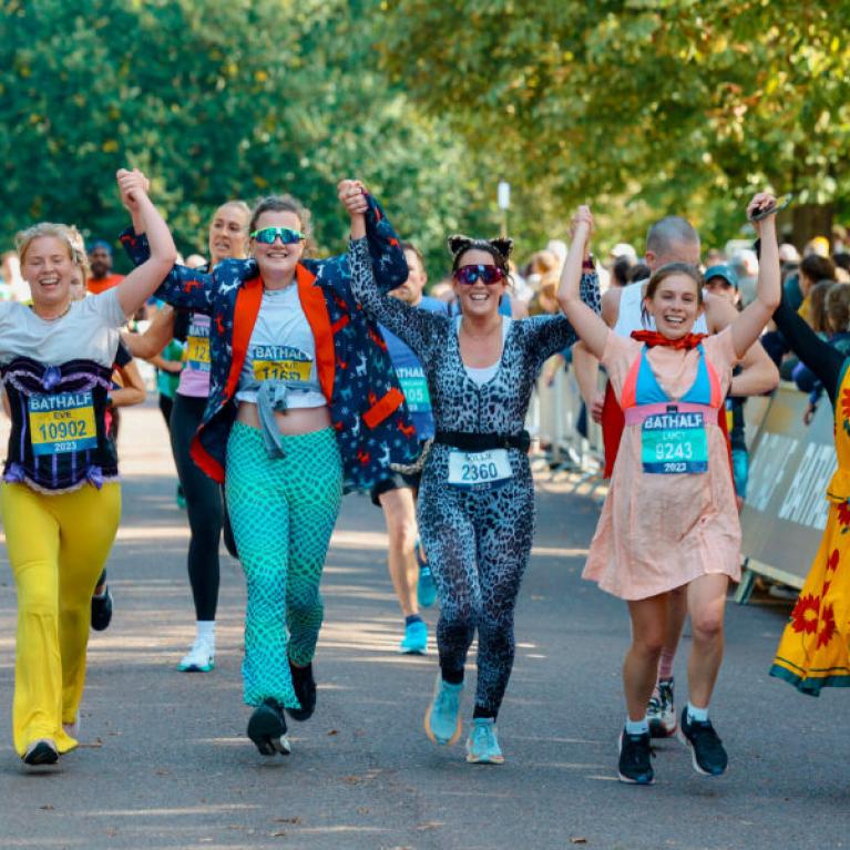 A bunch of people running a marathon dressed in fun outfits.