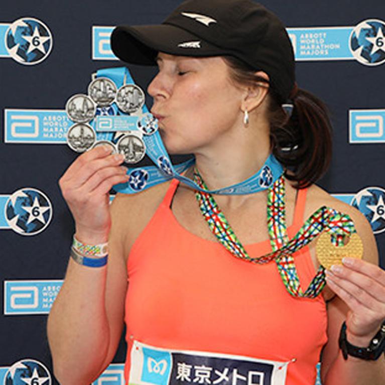 A woman kissing her medal.