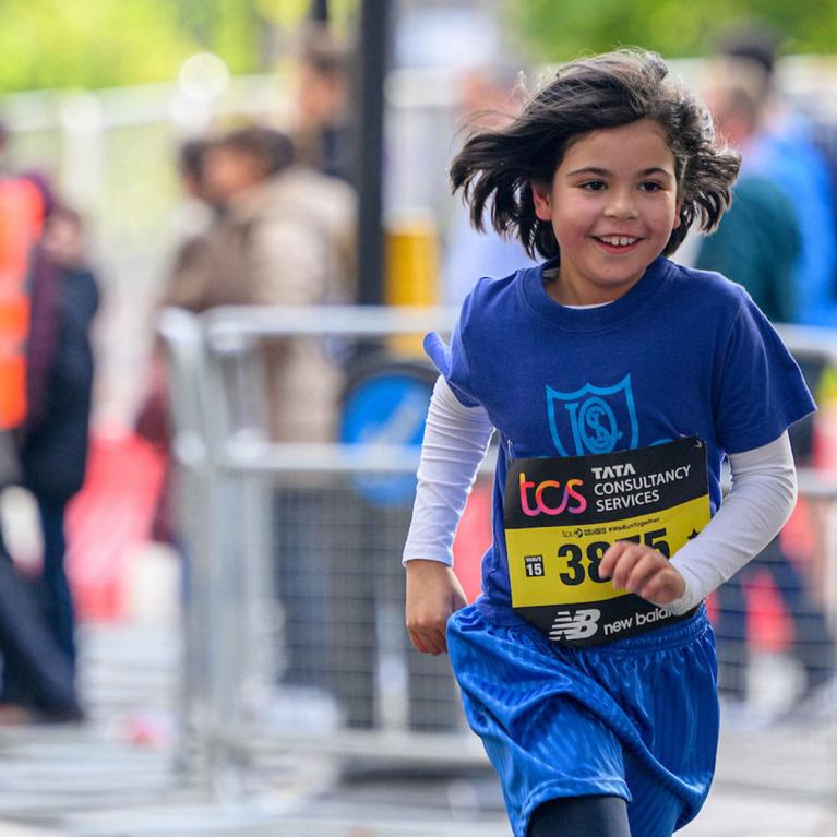 A young competitor in the race runs down The Mall during The TCS Mini London Marathon on Saturday 1st October 2022