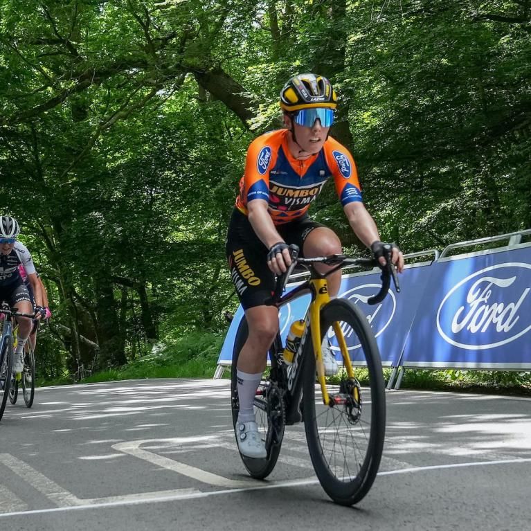 Elite cyclists ride past Ford branding